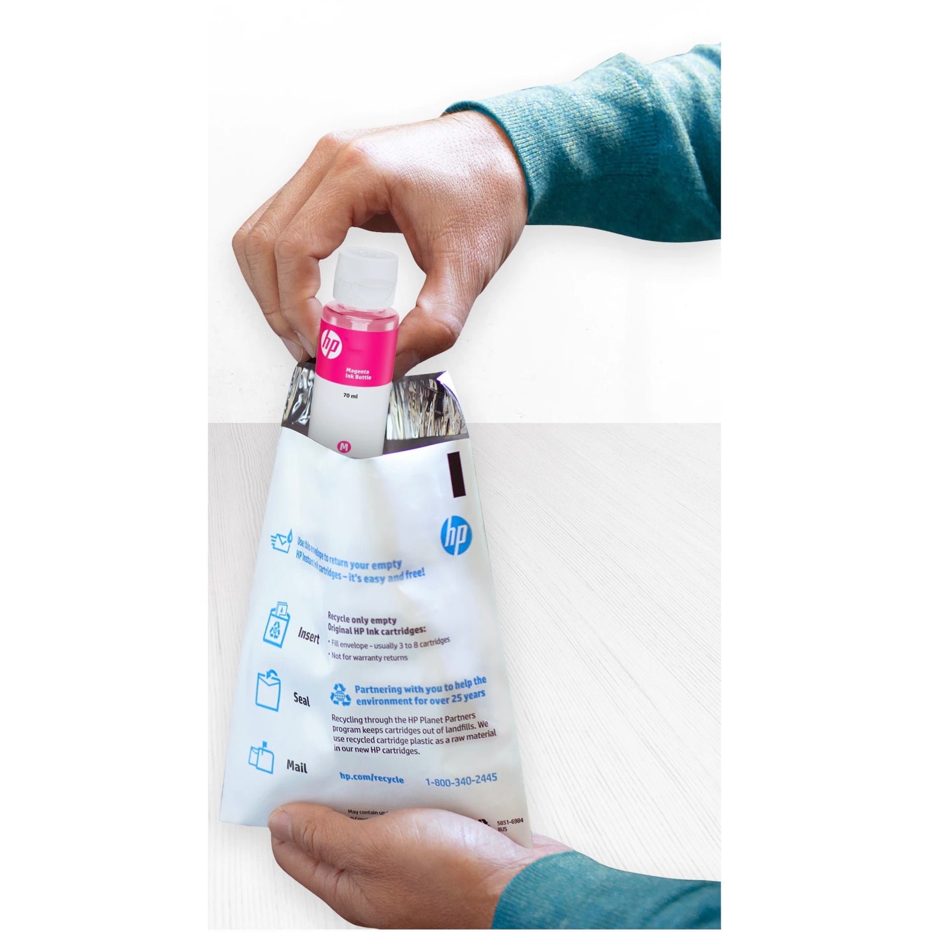 Hands holding HP ink bottle and recycling envelope showing recycling program instructions-alternate-image2