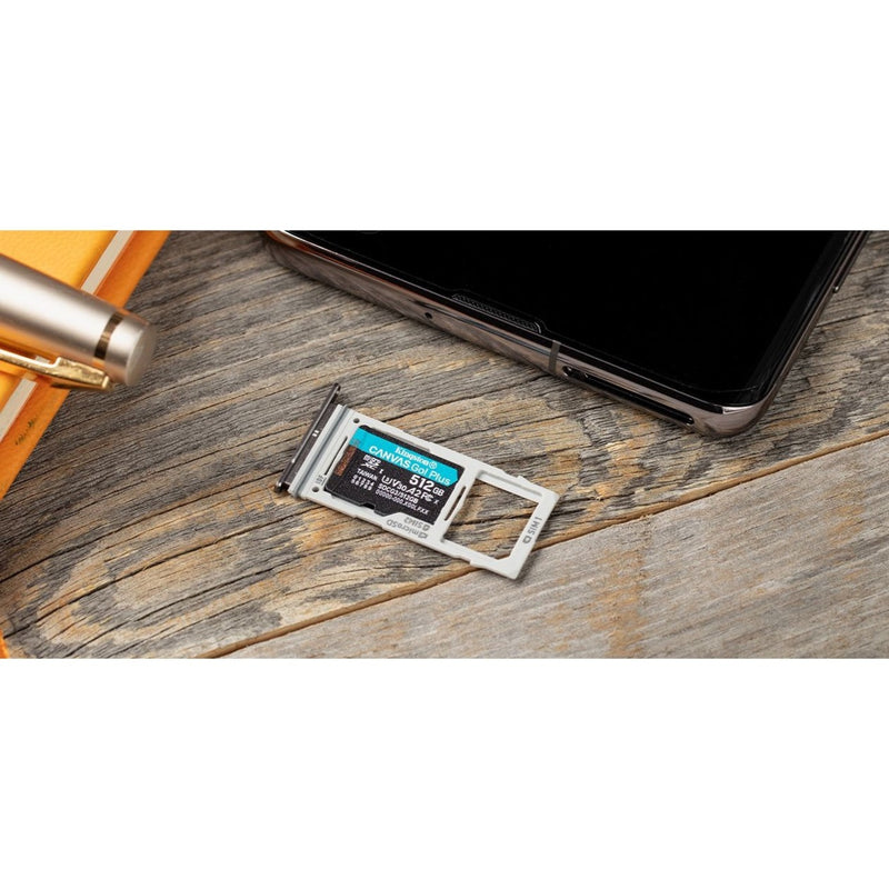 Kingston Canvas Go! Plus microSD card next to smartphone SIM tray on wooden surface