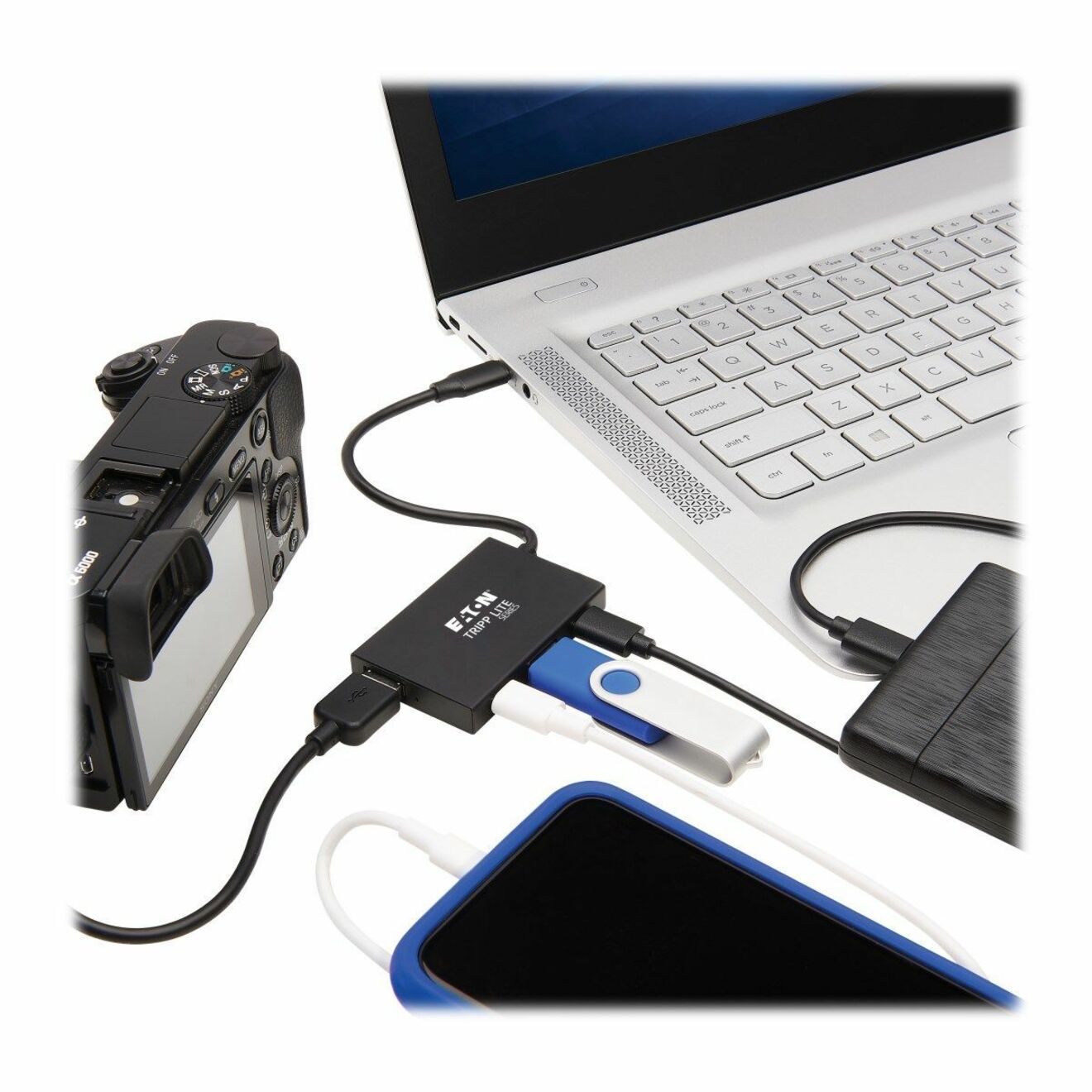 Tripp Lite USB hub connected to laptop showing multiple device connections including digital camera, USB drive, and smartphone-alternate-image1