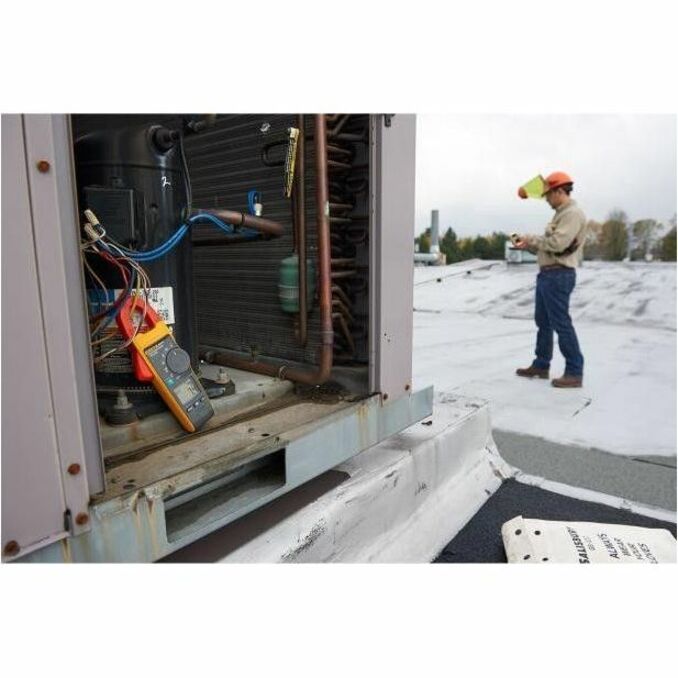 HVAC technician using Fluke 902 FC clamp meter for remote monitoring of rooftop unit-alternate-image2