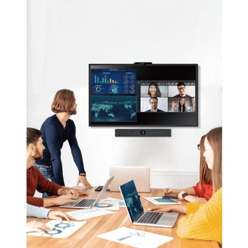 Team members collaborating in a meeting room using laptops while viewing shared content and video conference participants on a wall-mounted display-alternate-image2