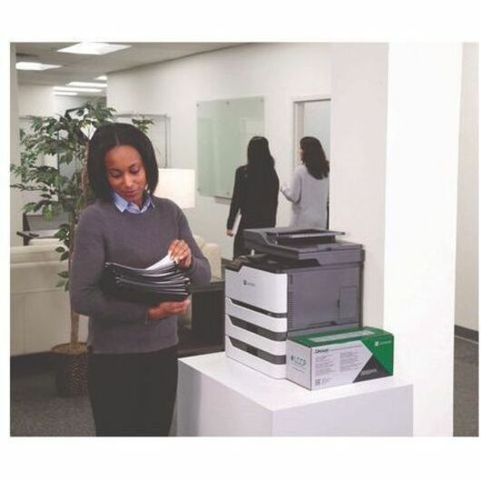 Office professional reviewing printed documents next to a Lexmark printer-alternate-image2