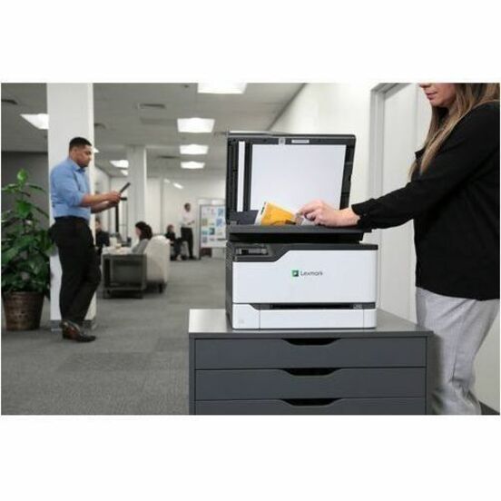 Business environment showing Lexmark printer in use with office workers in background