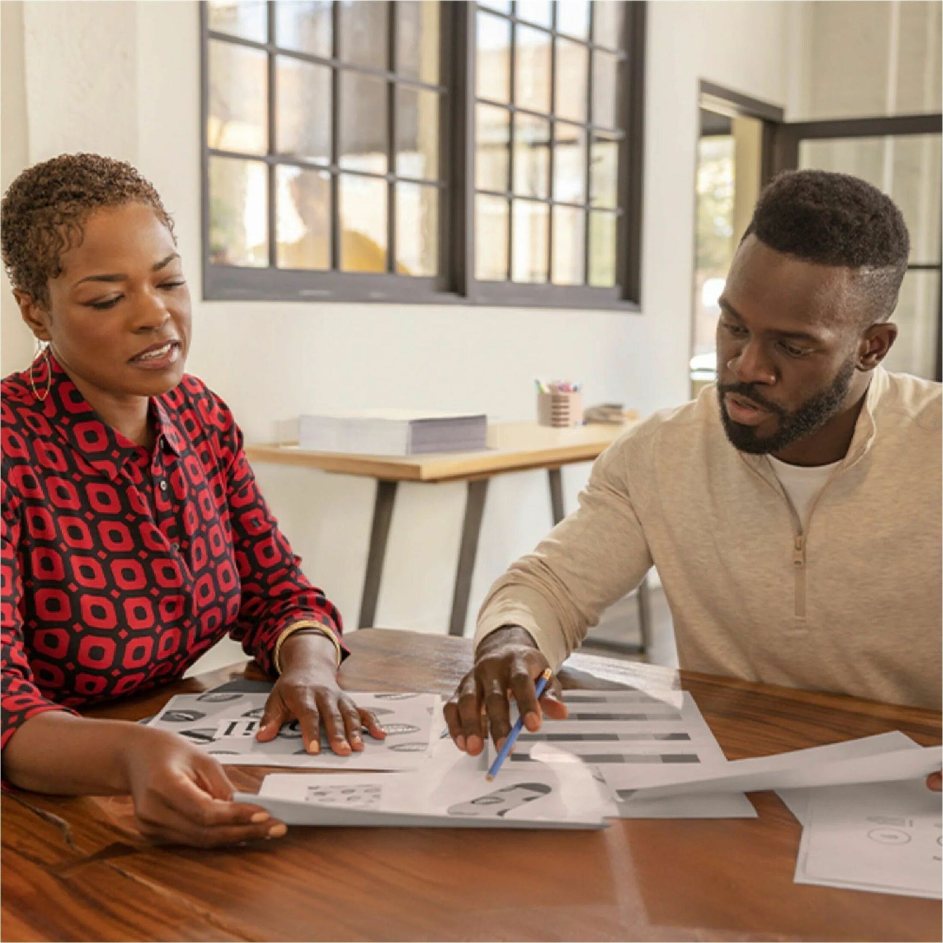 Team members collaborating over printed materials in office setting-alternate-image4