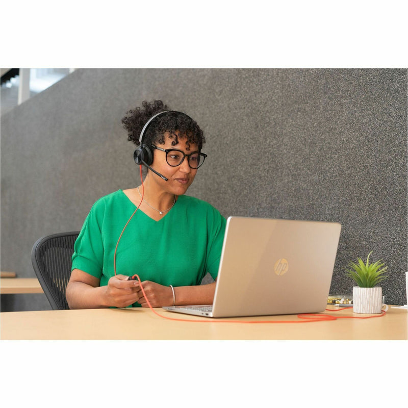 Professional using Poly Blackwire headset in office setting