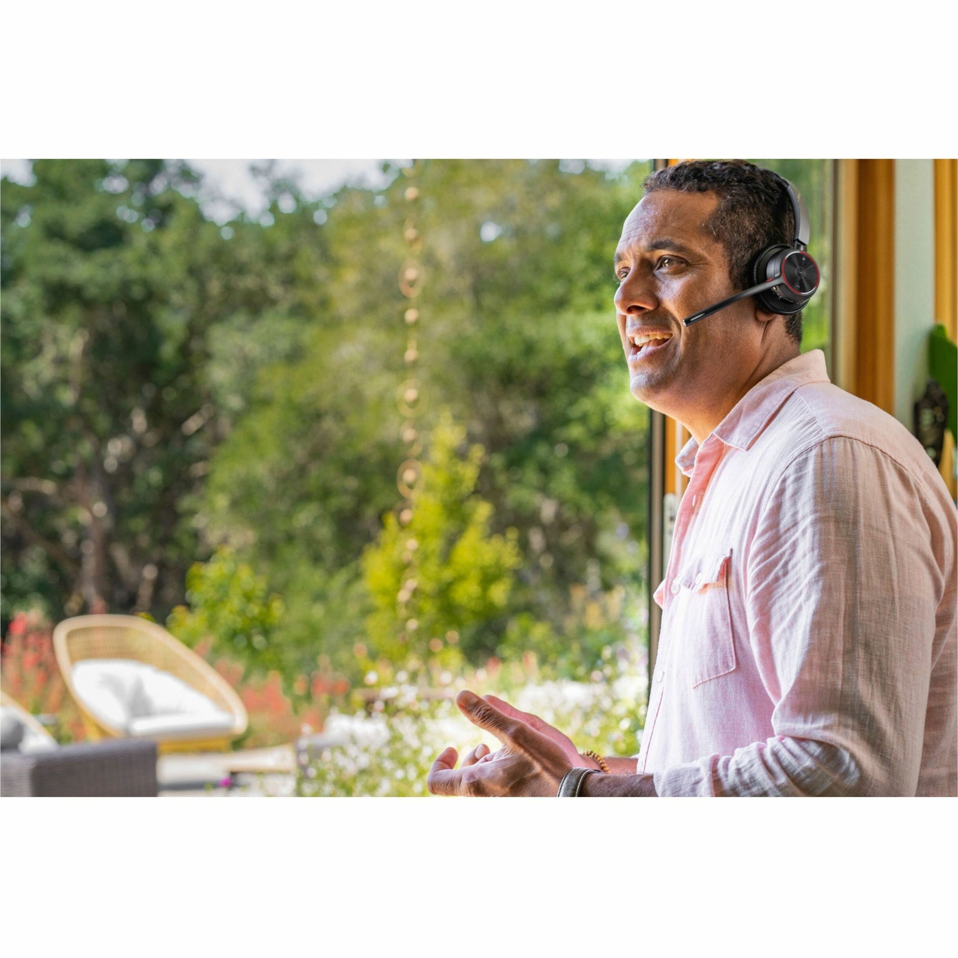 Person using Poly Voyager headset while standing and gesturing during conversation-alternate-image5