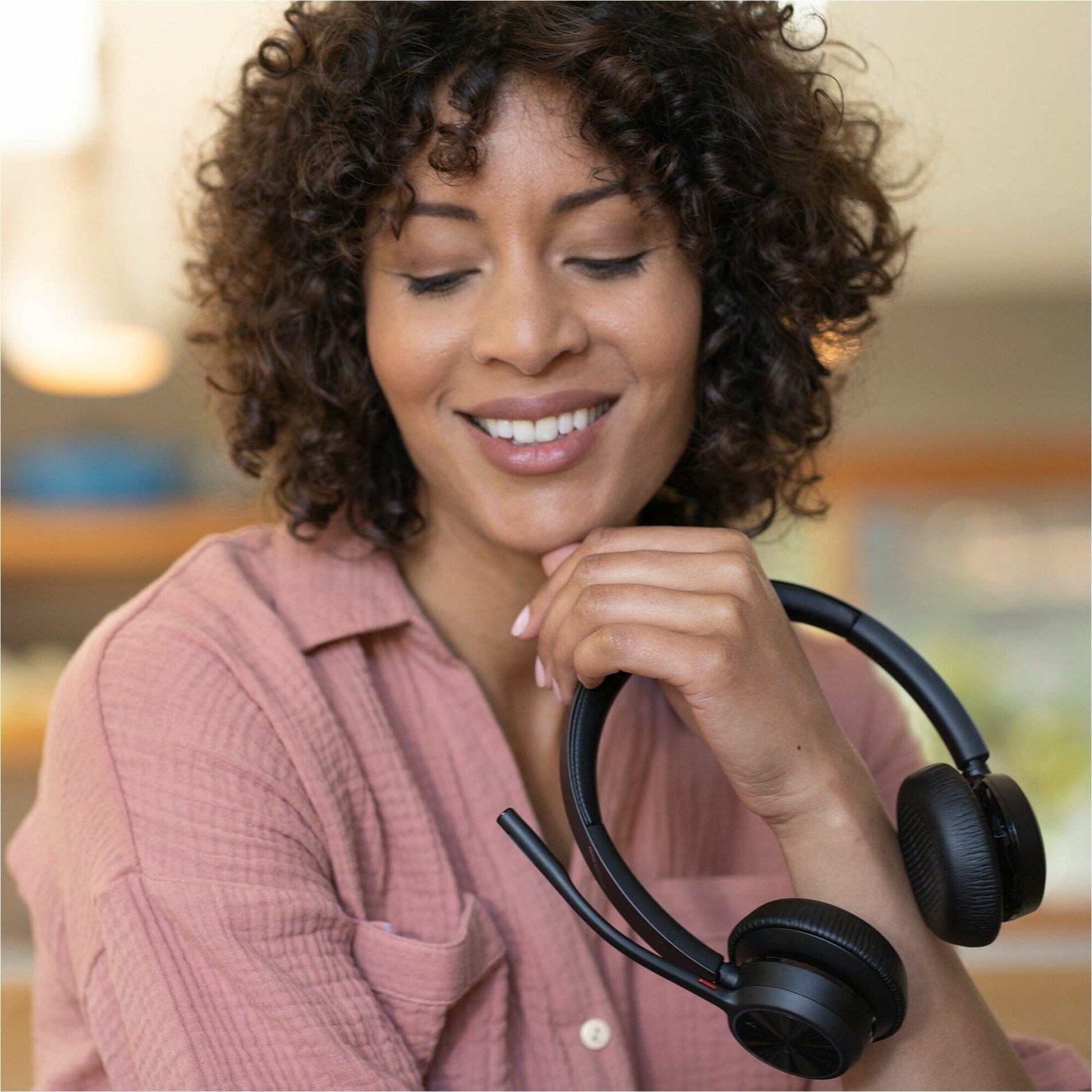 Person wearing Poly Voyager 4320-M headset in home office setting-alternate-image6