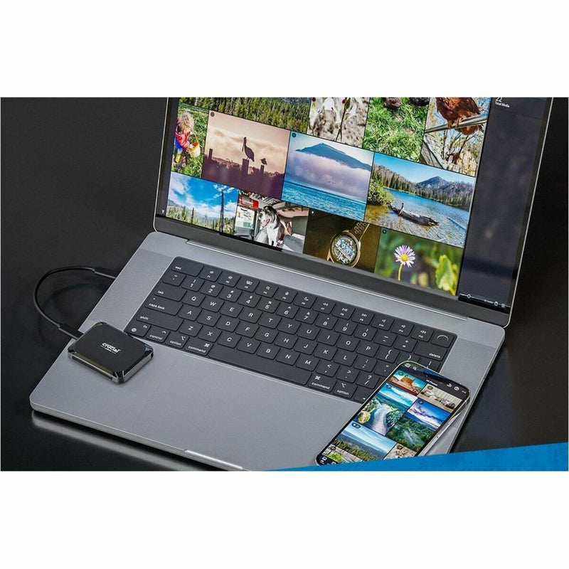 Crucial X9 SSD connected to laptop displaying photo library and editing interface