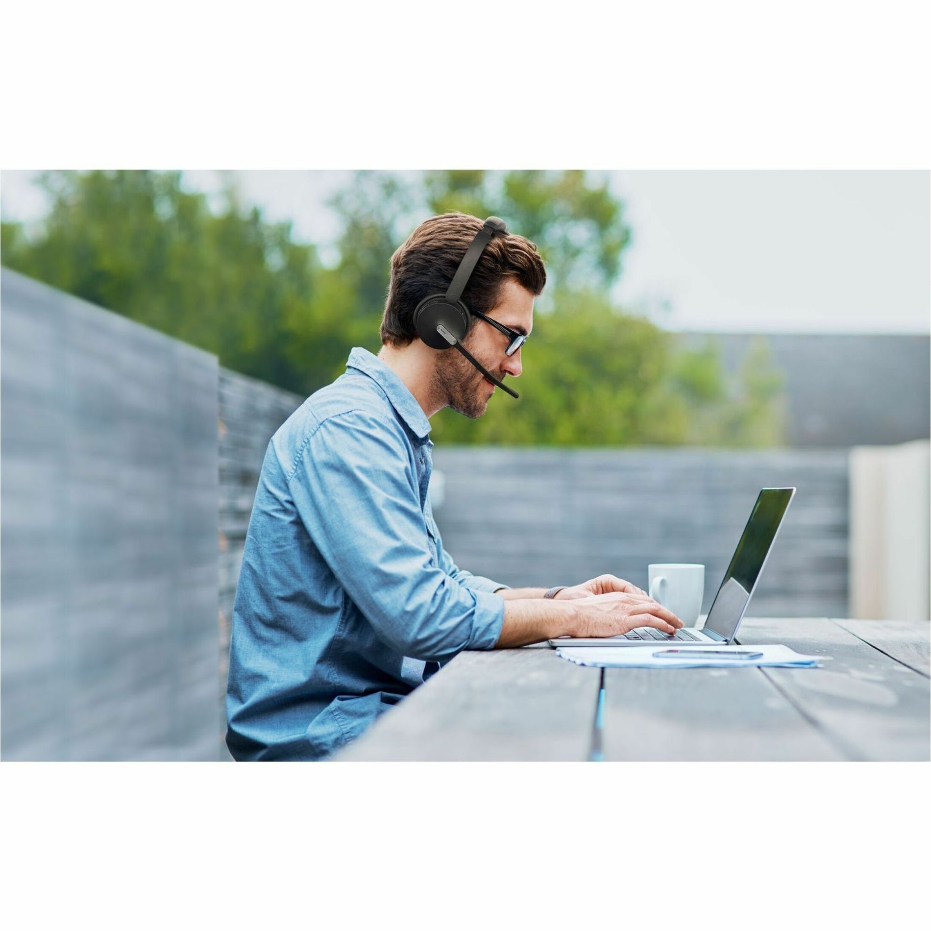 Professional using Yealink BH70 headset in outdoor workspace setting-alternate-image5