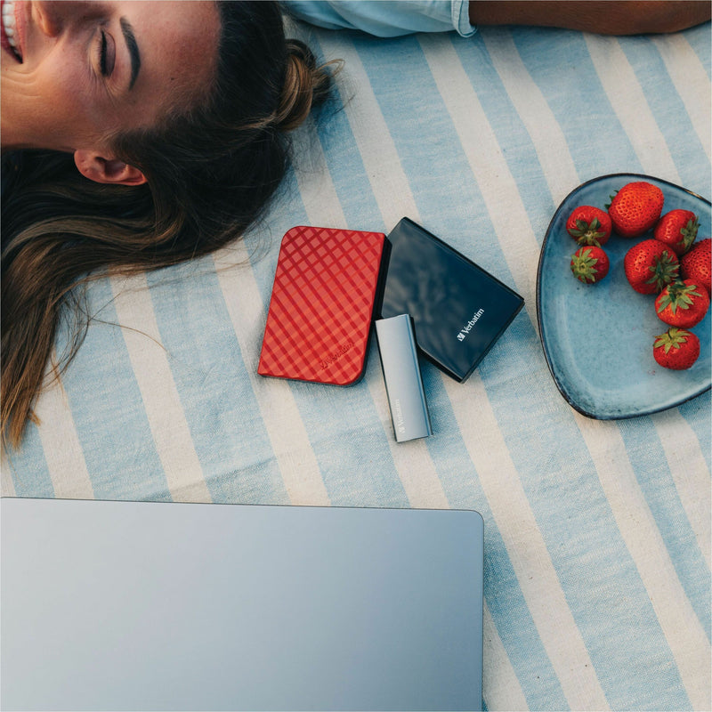 Lifestyle image showing Verbatim VX500 SSD in casual setting with laptop