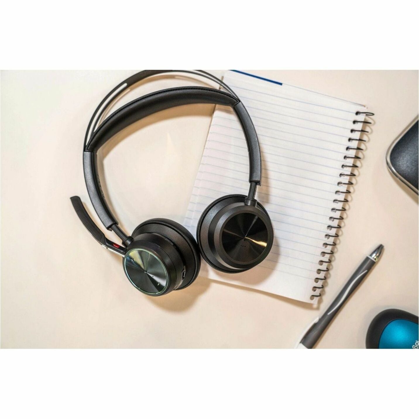 Poly Voyager Focus 2 headset on desk with notebook-alternate-image11