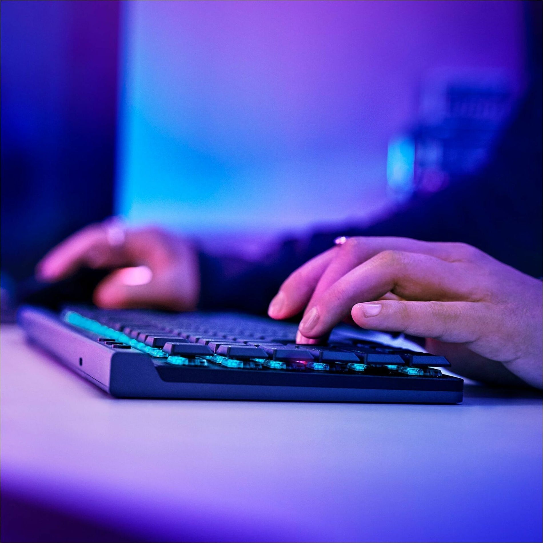 Side view of hands typing on G515 keyboard with purple and blue ambient lighting-alternate-image4