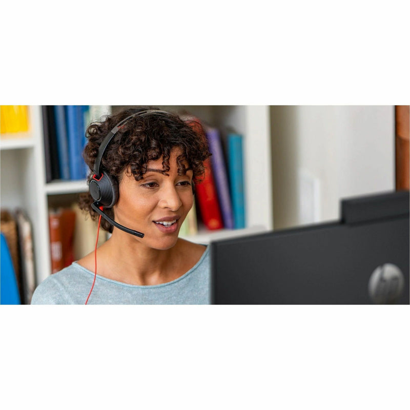 Professional using Poly Blackwire 5210 headset during a video conference in an office setting