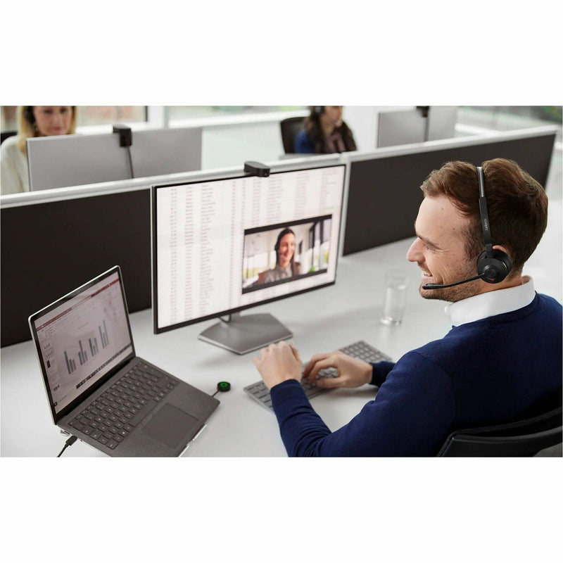 Professional using Jabra headset at desk with multiple monitors