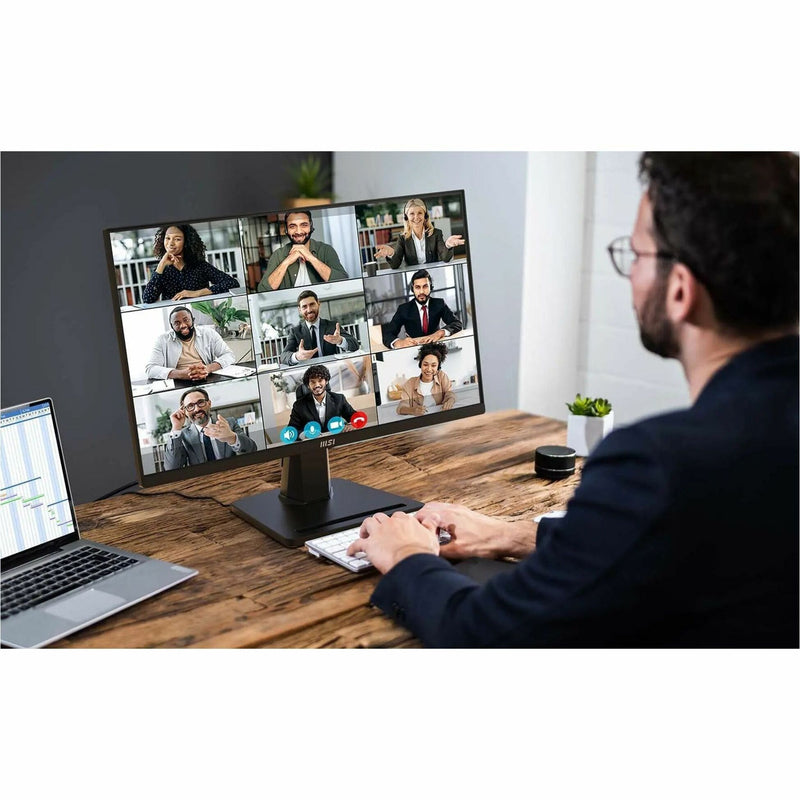 Professional using MSI PRO MP245G for virtual meeting with multiple participants