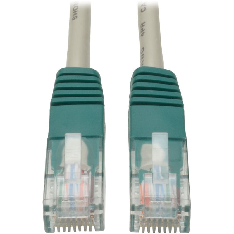 Close-up view of two green RJ45 connectors on Tripp Lite Cat5e crossover cable showing transparent housing and internal wiring