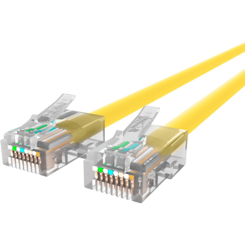 Close-up view of gold-plated RJ45 connectors on yellow CAT6 ethernet cable showing internal wiring