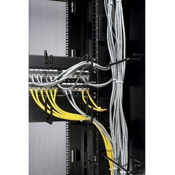 Close-up side view of network cables routed through horizontal cable organizer showing yellow and white cables