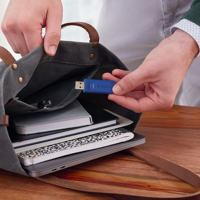 Person accessing Verbatim USB drive from bag with notebooks