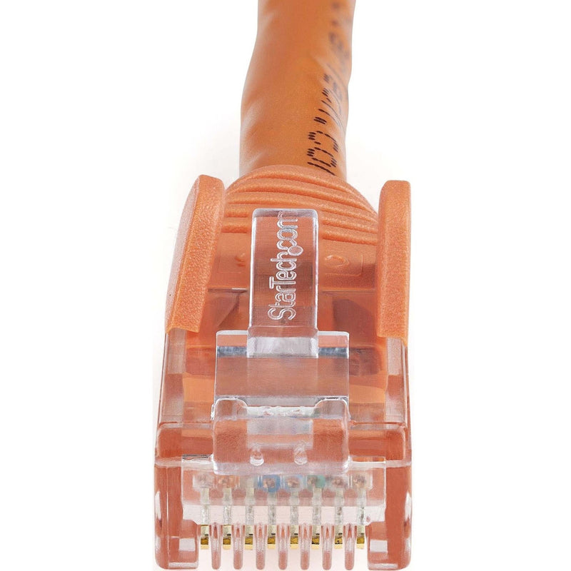 Macro shot of orange Cat6 cable RJ45 connector showing gold-plated contact pins and internal wiring