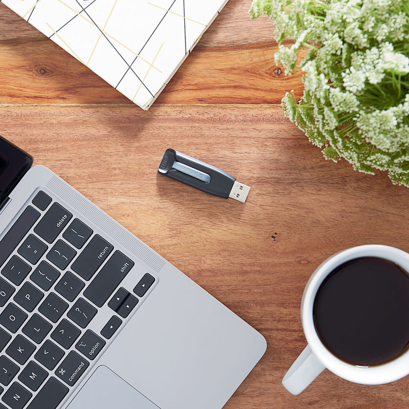 USB drive on desk with laptop, coffee cup, and office accessories