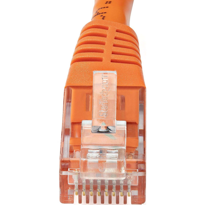 Detailed macro shot of RJ45 connector showing gold-plated pins and StarTech branding on orange ethernet cable