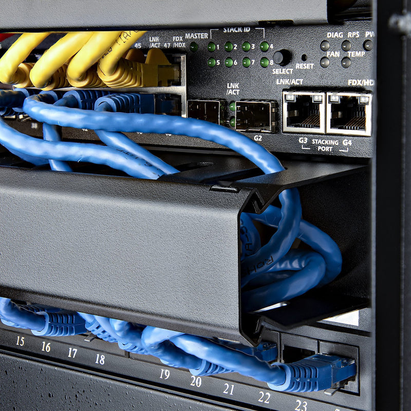 Cable management panel shown in active use managing network cables in server rack