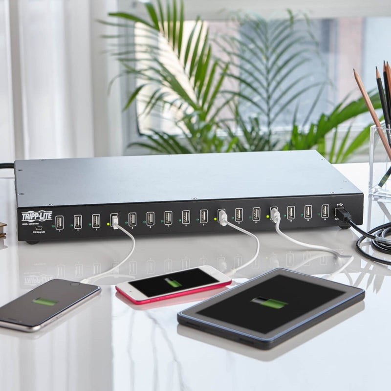 Tripp Lite USB charging hub actively charging multiple mobile devices on a desk with clean cable management