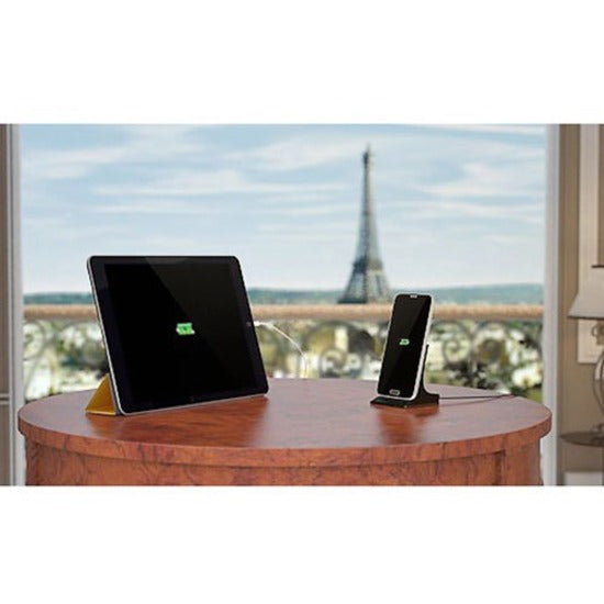 USB charger powering tablet and phone with Eiffel Tower view