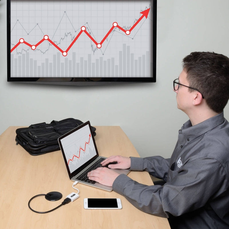 Business professional using dual displays with financial charts