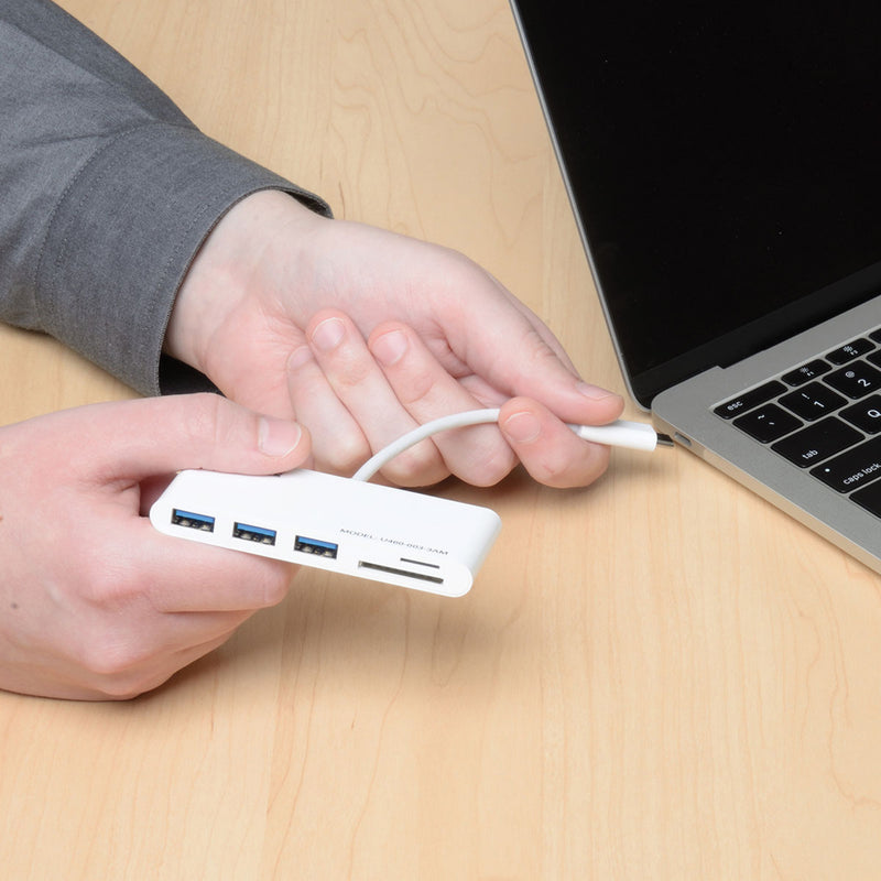 Hands connecting USB hub to laptop showing ease of use