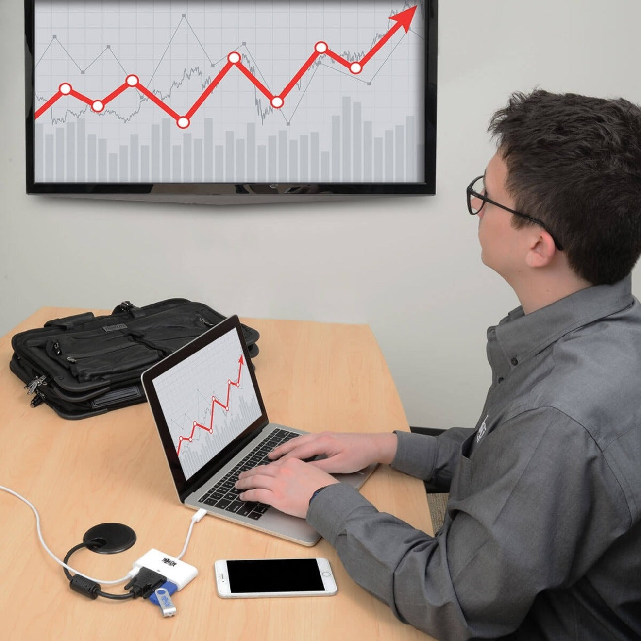 Person using laptop connected to external monitor showing data charts with Tripp Lite adapter-alternate-image2