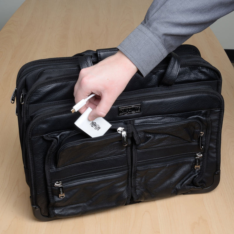 Tripp Lite USB hub being placed in a laptop bag demonstrating portability