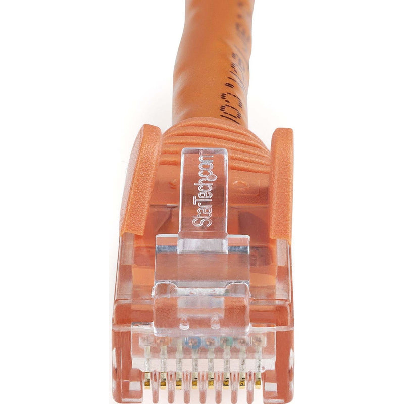 Detailed macro shot of orange Cat6 ethernet connector showing internal pin configuration and StarTech.com branding