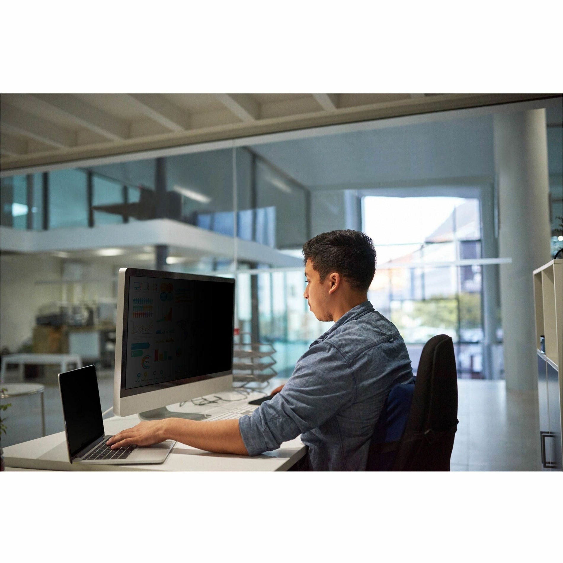 Professional working at desk with privacy filter installed on monitor in modern office setting-alternate-image3