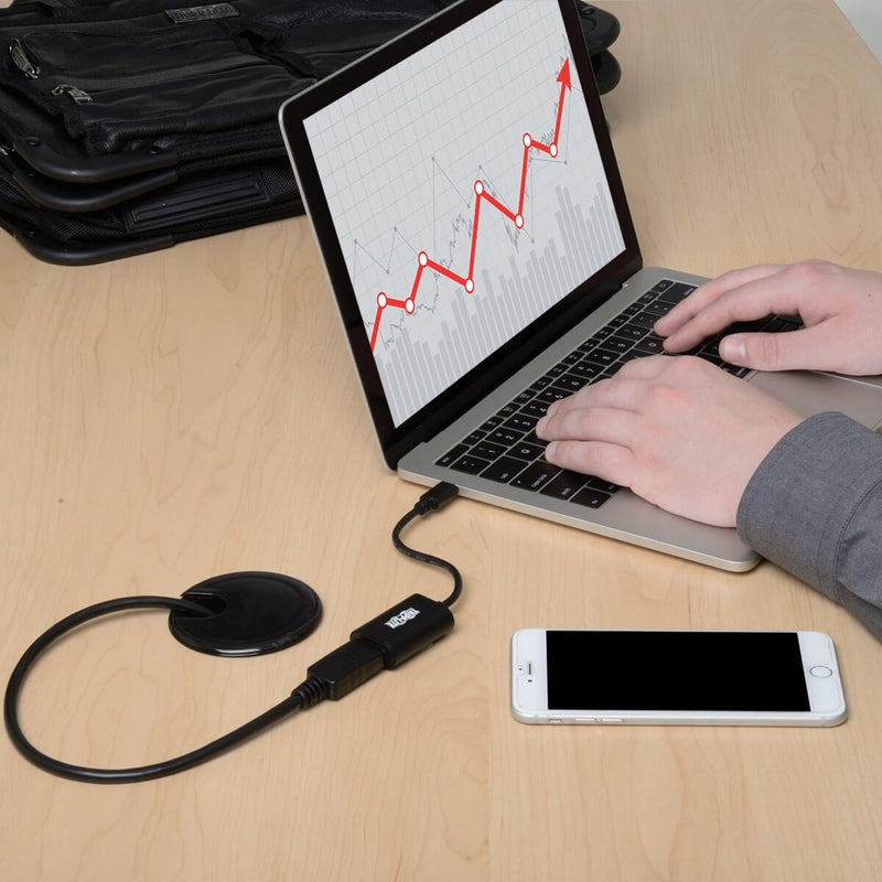 Close-up of laptop setup with Tripp Lite adapter connected showing clean desk organization