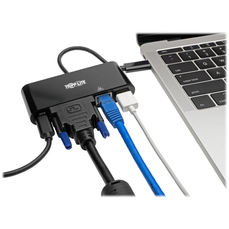 Tripp Lite docking station connected to laptop with multiple cables including DVI, Ethernet, and USB