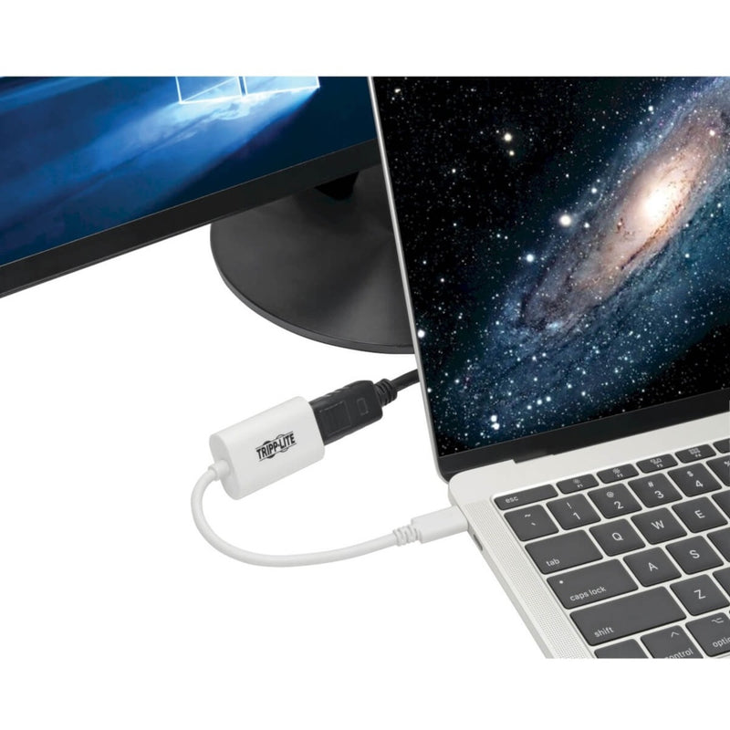 Tripp Lite adapter connected to MacBook displaying galaxy image on external monitor