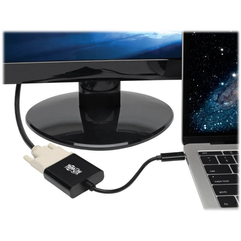 Tripp Lite USB-C to DVI adapter connected between a MacBook and monitor showing practical usage