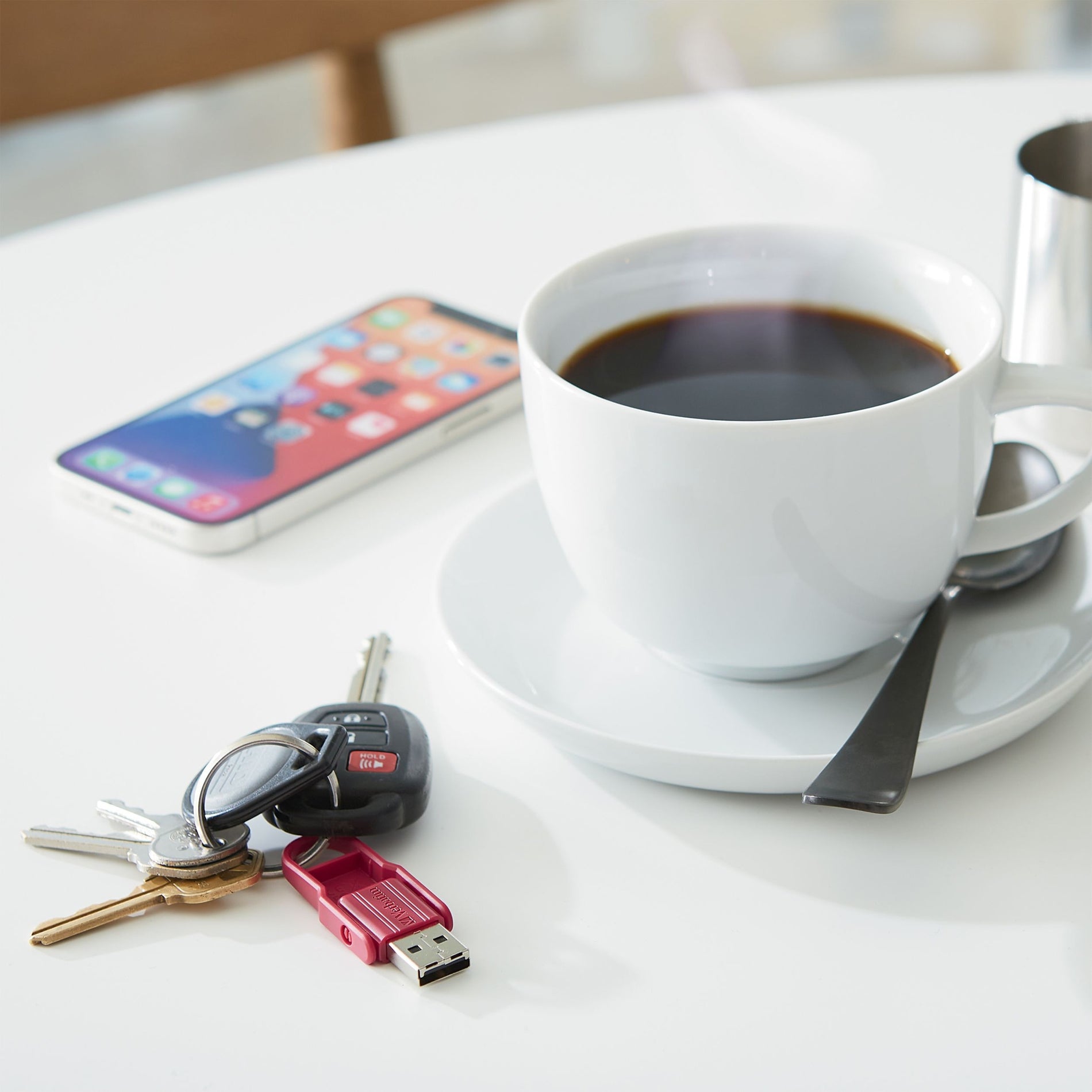 Lifestyle image with Store 'n' Flip USB drive, coffee cup, and mobile device-alternate-image12