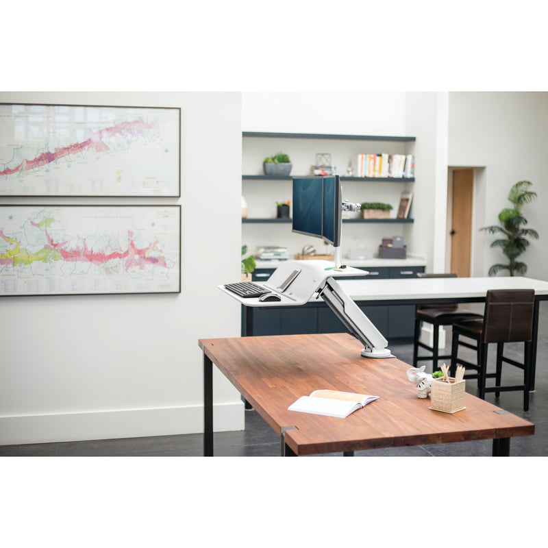 Office environment showing Levado desk system integration with monitor arm and ergonomic accessories