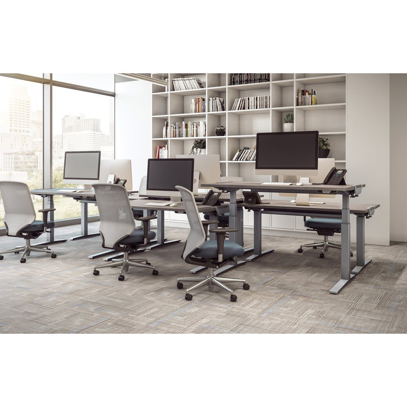 Multiple Fellowes Levado desks arranged in an open office environment with bookshelf background