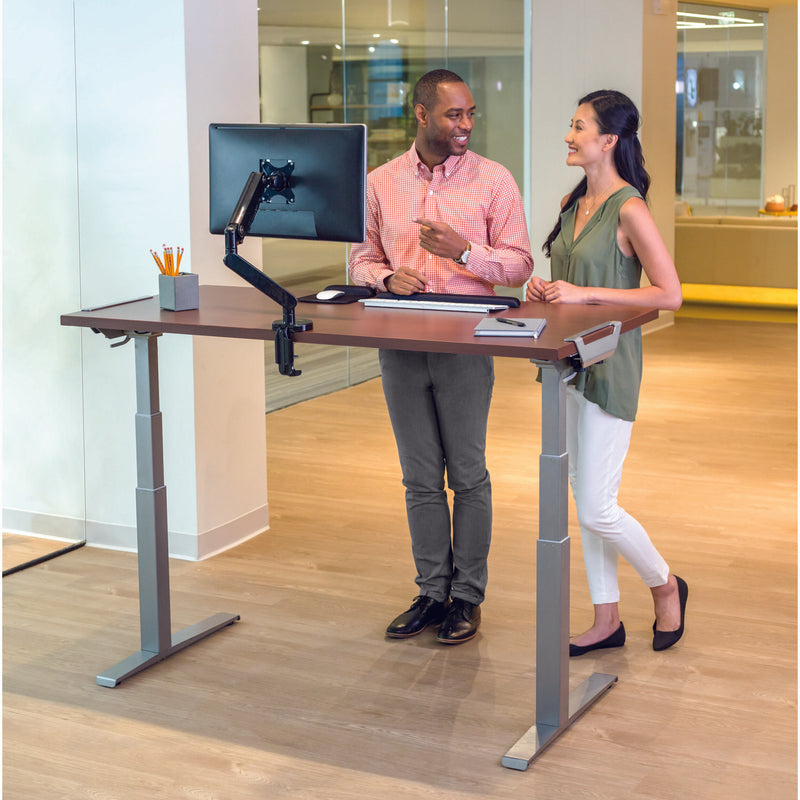 Two professionals collaborating at Levado standing desk with mounted monitor