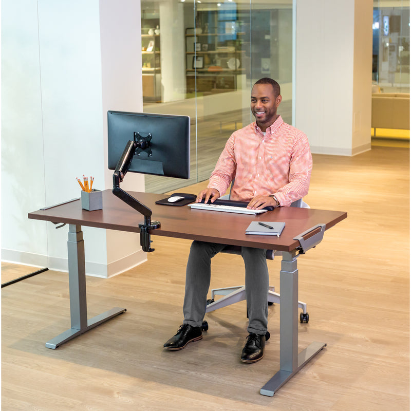 Professional working at Levado standing desk with mounted monitor