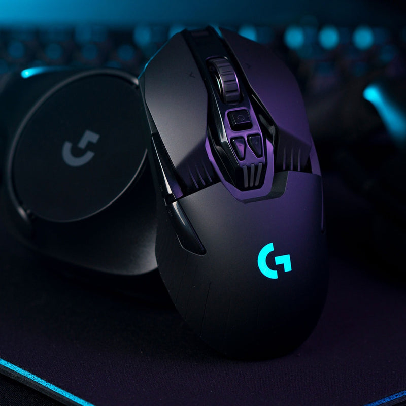 Atmospheric shot of G903 mouse with blue RGB lighting on a gaming surface