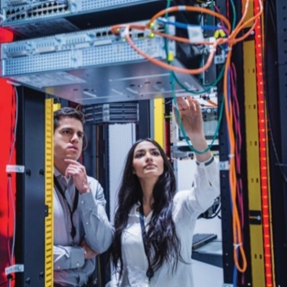 IT professionals examining network infrastructure in a data center with APC equipment