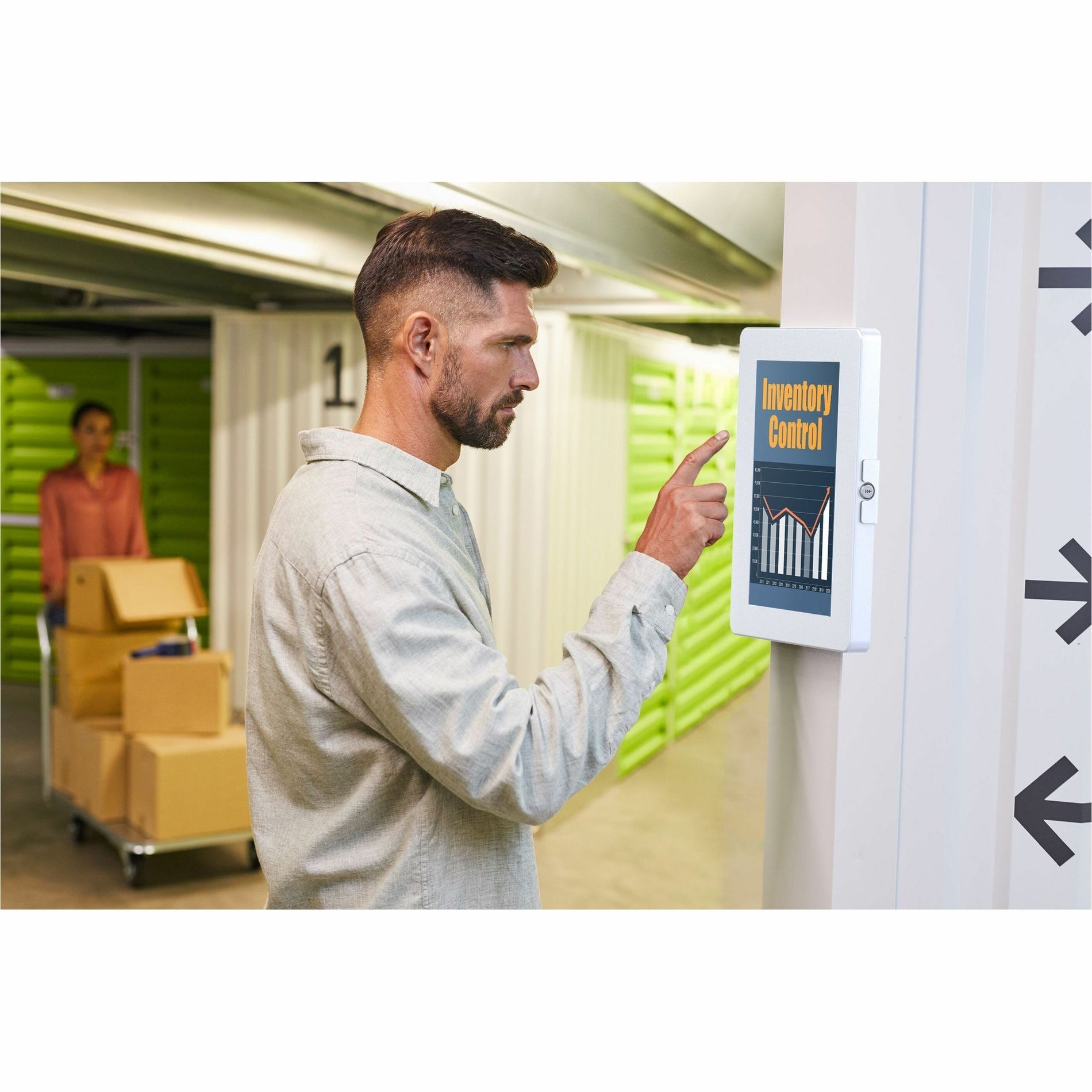 Professional using wall-mounted tablet for inventory management in warehouse setting-alternate-image6