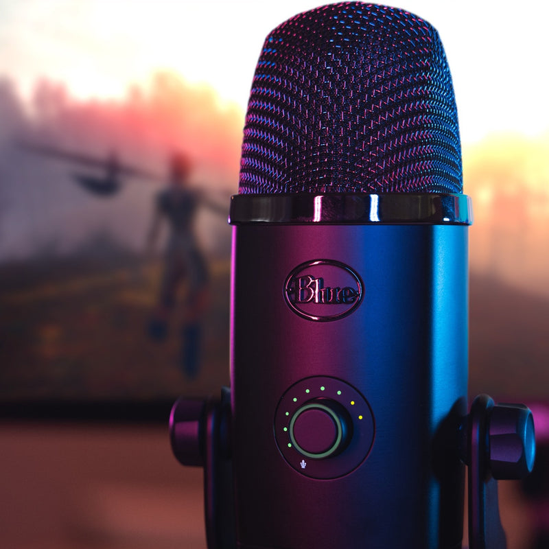 Close-up of Blue Yeti X microphone with colorful RGB lighting against sunset background