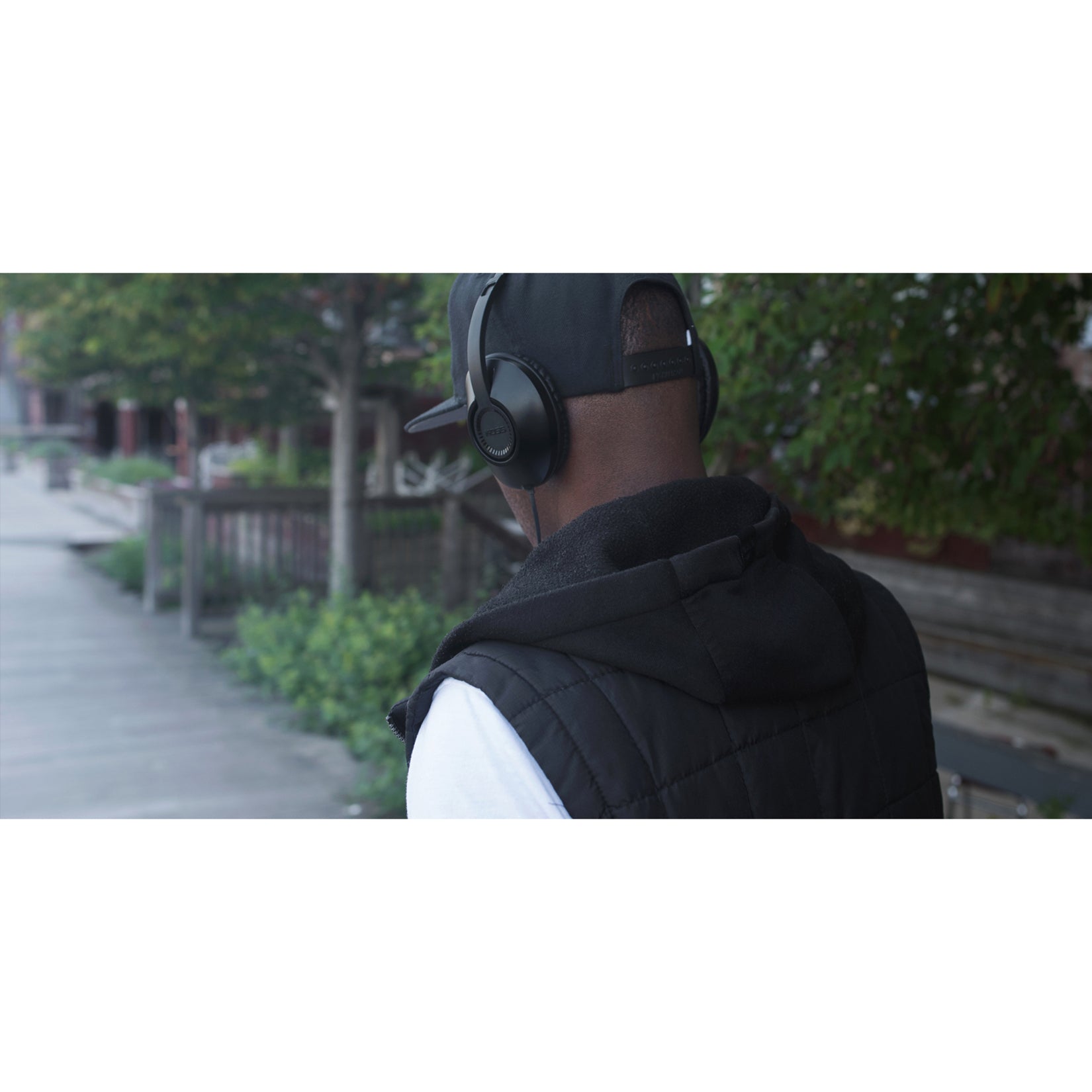 Person wearing Koss UR23i headphones outdoors in urban setting-alternate-image6