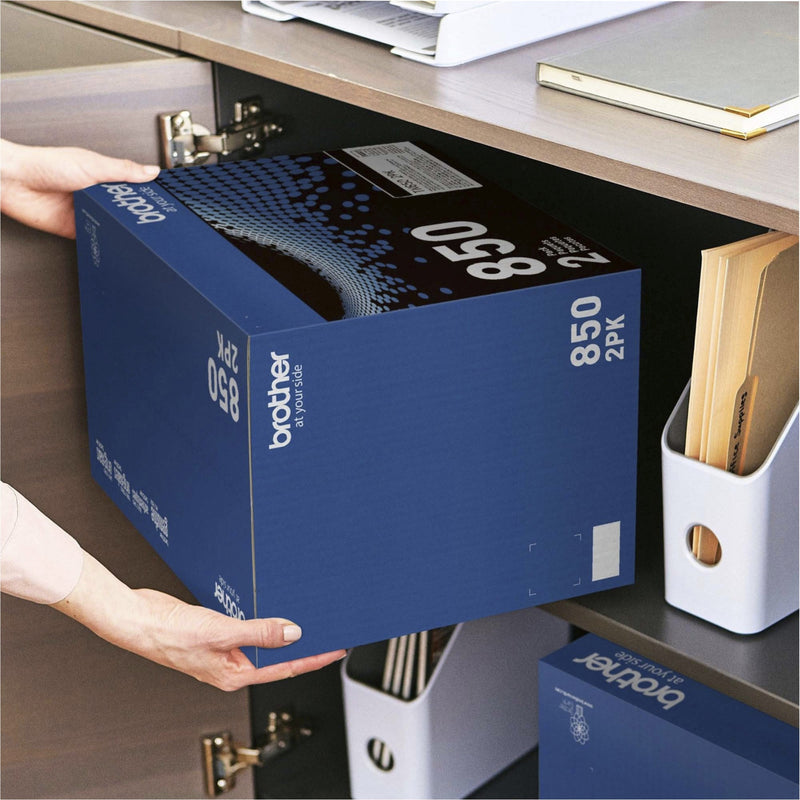 Hands storing Brother TN850 2PK toner box in office cabinet